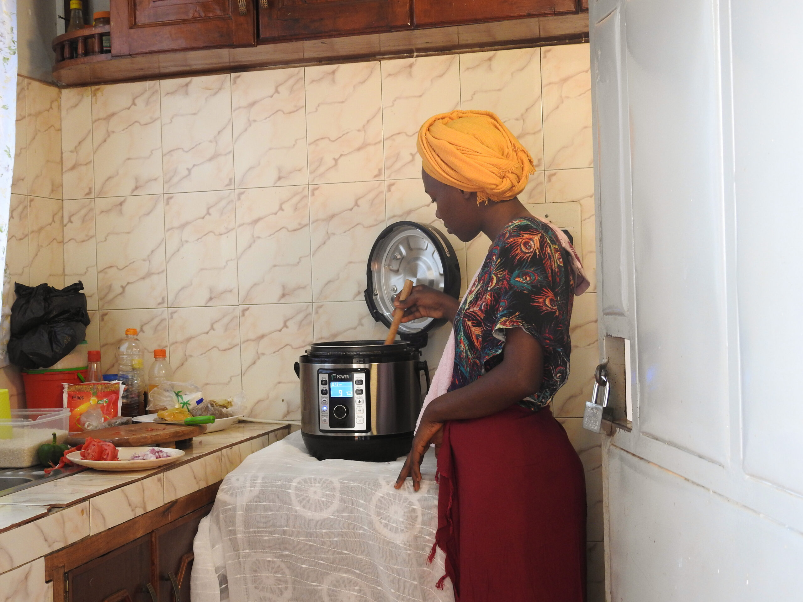 Lady cooking with electric cookstove. Image used with permission - credit UpEnergy.